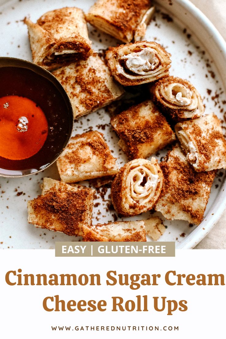 cinnamon sugar cream cheese roll ups on a white plate with dipping sauce in the middle