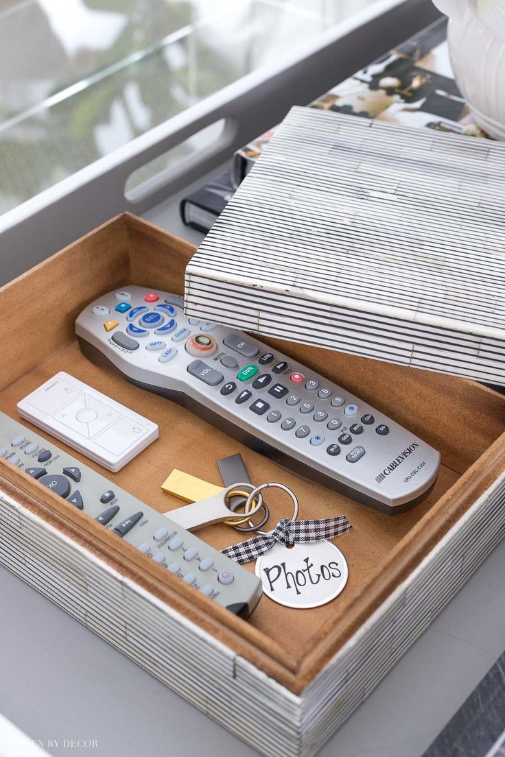 several remote controls and tags in a wooden box