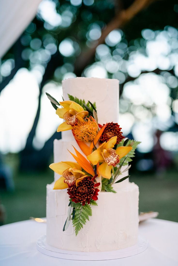 a white wedding cake with flowers on top