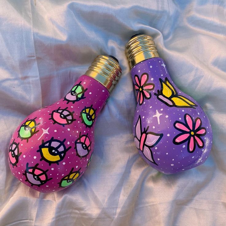 two purple light bulbs with flowers painted on them