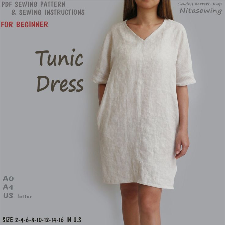 a woman standing in front of a white wall with the words tunic dress on it