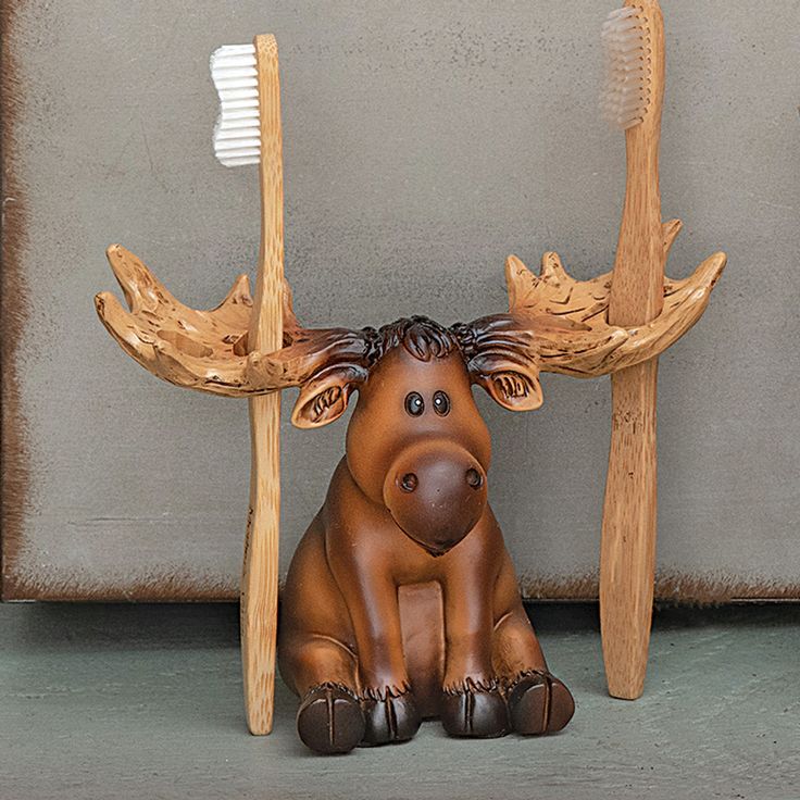 a statue of a moose with two toothbrushes in it's antlers