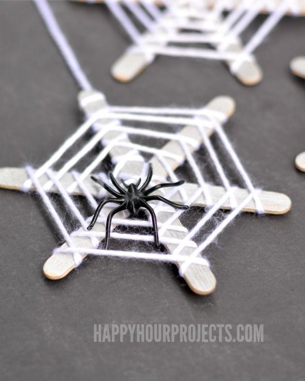 a black and white spider sitting on top of a piece of paper with holes in it