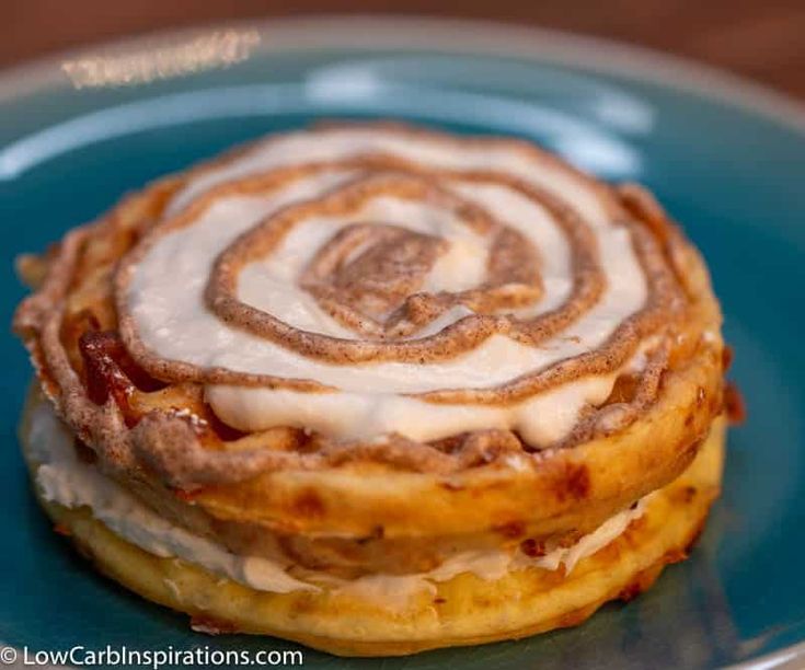 a stack of cinnamon rolls sitting on top of a blue plate