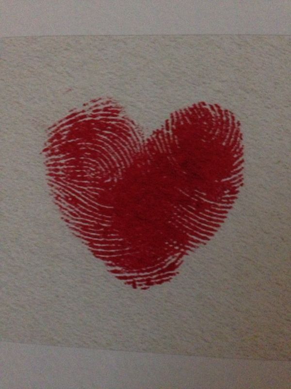 a fingerprint in the shape of a heart on a piece of paper with red ink