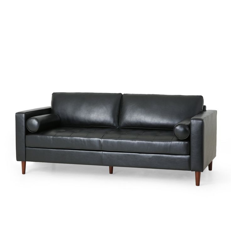 a black leather couch sitting on top of a white floor