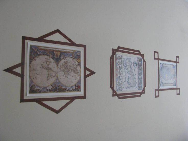 three framed maps hang on the wall next to each other in an artful manner