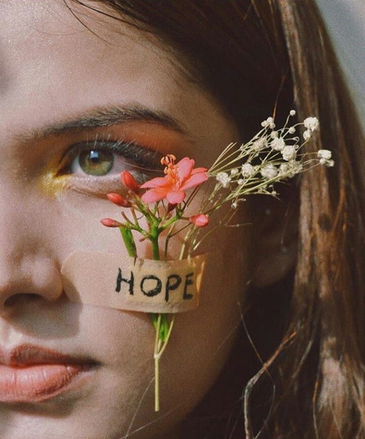 a woman with flowers on her face and the word hope written on it