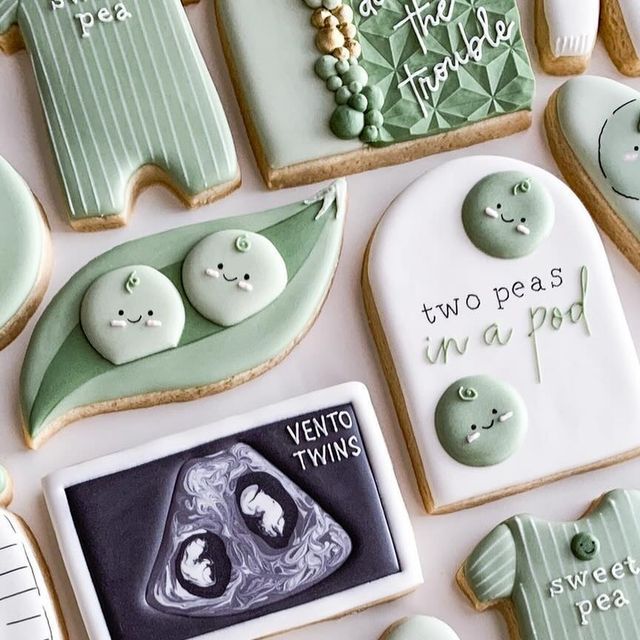 decorated cookies are arranged in the shape of pea pods, peas and two peas on them