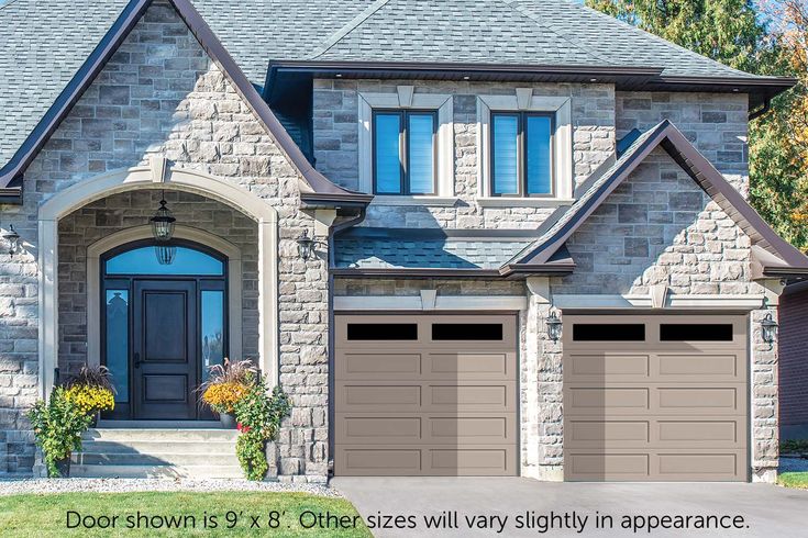 a house with two garage doors and three windows on the front of it is shown