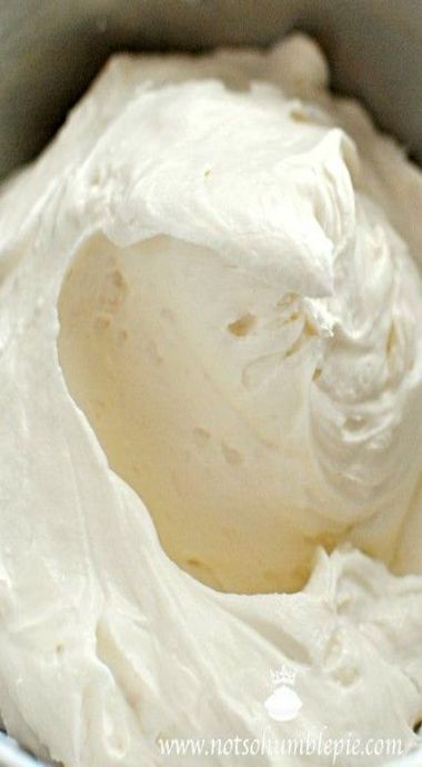 a metal bowl filled with whipped cream on top of a table