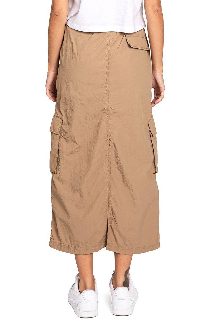 Chic, parachute skirt with an elastic waistband, a drawstring cinch tie and cargo pockets down the sides. Pair it with a graphic tee and sneakers for an effortless streetwear look. CARE | Machine Wash Cold CONTENTS | 100% Nylon MEASUREMENTS | 33"/85 cm Top to Bottom (Size Small) MODEL | 5'8 - wearing a size Small IMPORTED Casual Cargo Skirt With Drawstring For Summer, Casual Drawstring Cargo Skirt For Summer, Casual Summer Cargo Skirt With Drawstring, Casual Khaki Cargo Skirt With Pockets, Casual Summer Cargo Skirt, Cotton Cargo Skirt With Drawstring For Spring, Spring Nylon Cargo Skirt With Pockets, Casual Spring Cargo Skirt With Pockets, Casual Khaki Cargo Skirt For Spring