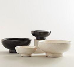 black and white bowls are sitting next to each other on a table with one bowl in the middle