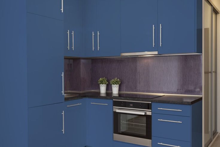 a kitchen with blue cabinets and an oven