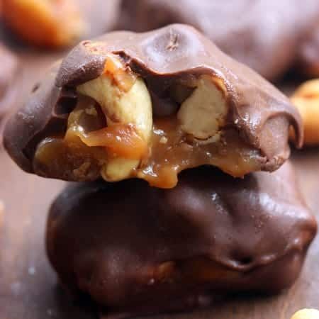 chocolate covered cookies are stacked on top of each other with nuts in the middle,