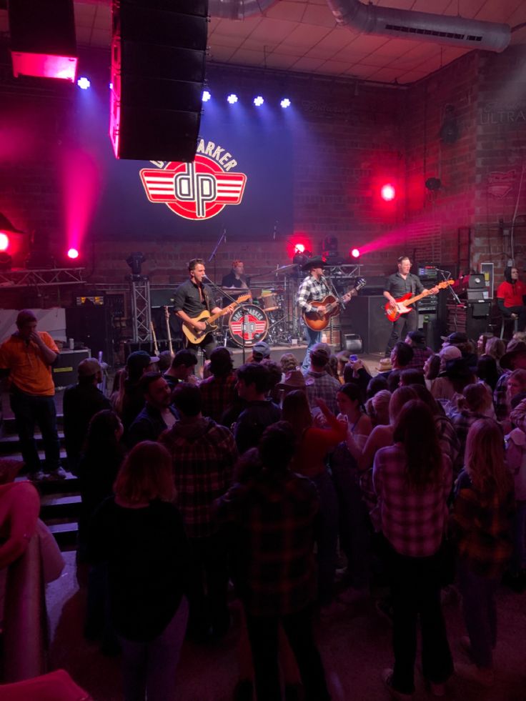 a group of people standing on top of a stage next to each other in front of a crowd