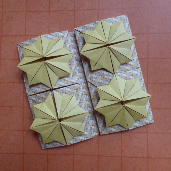 four origami umbrellas sitting on top of a tile floor next to each other