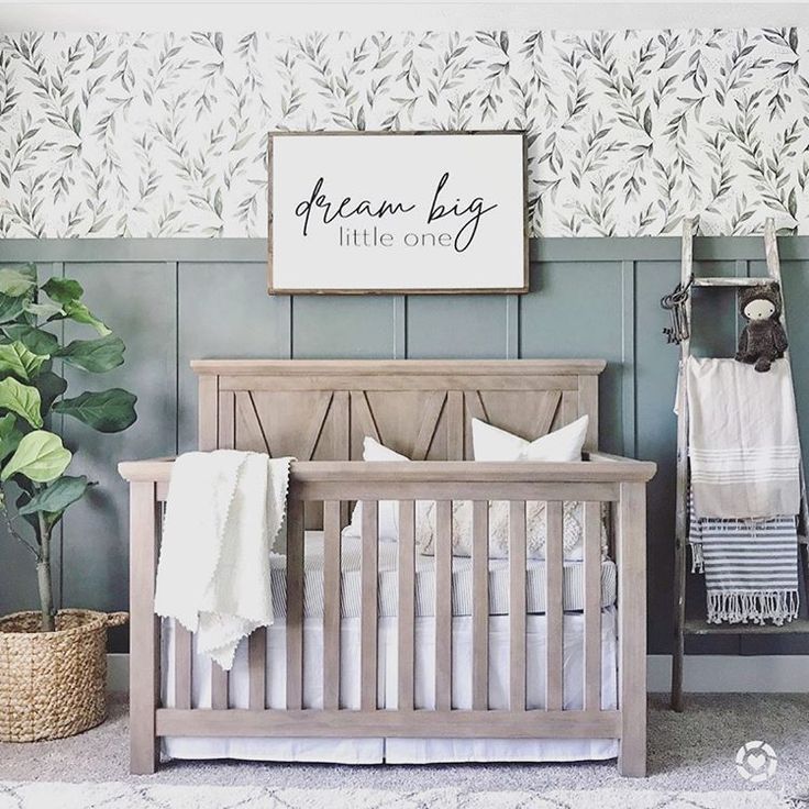 a baby's room with a crib, blanket and potted plant on the floor