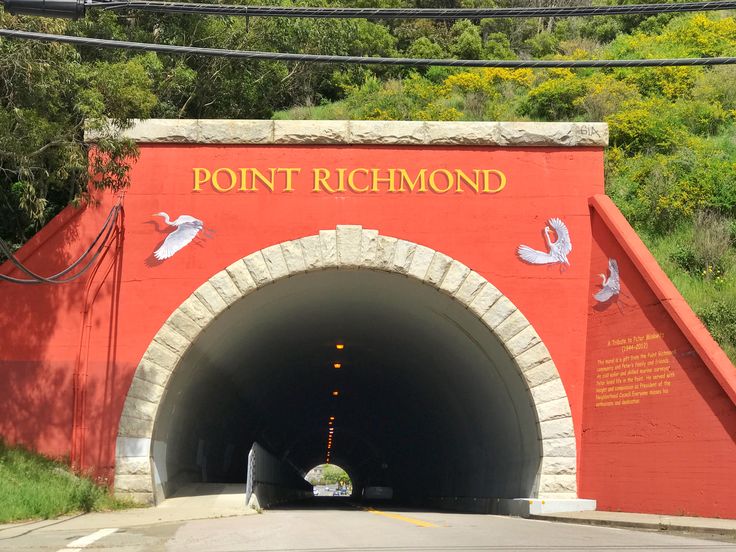 there is a red tunnel with white birds on it and the word point richmond written in gold