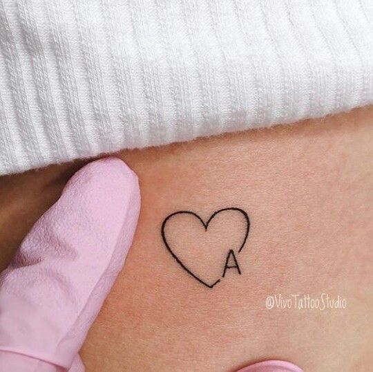 a small heart tattoo on the stomach