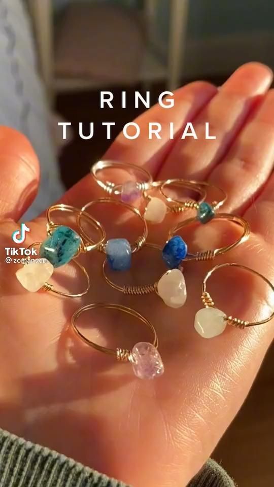 a person's hand holding seven rings with different colored stones on them and the words ring tutorial written below