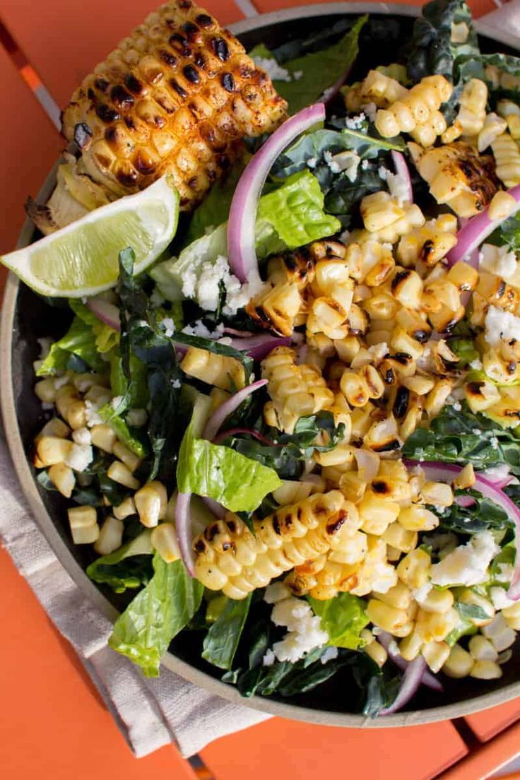 a bowl filled with corn and vegetables on top of a table