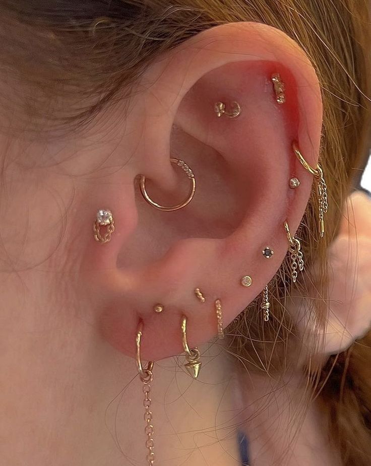 a close up of a person's ear with several different piercings on it