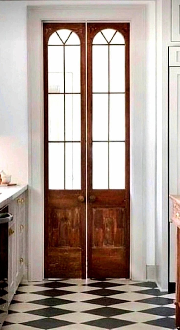 a kitchen with a checkered floor and wooden door