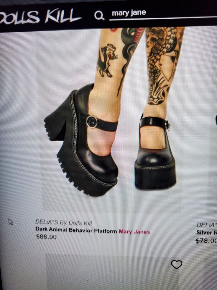 a woman's foot with tattoos on her leg wearing black platform shoes and heels