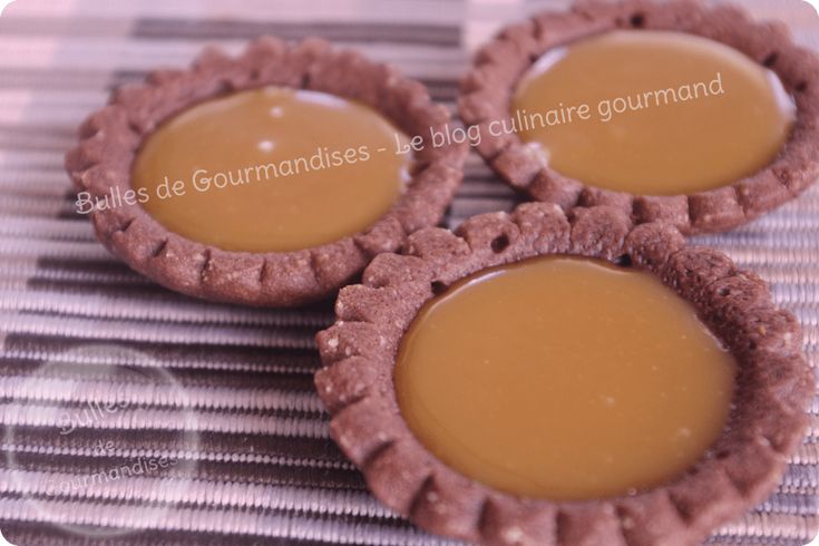 three cookies with caramel filling sitting on a table