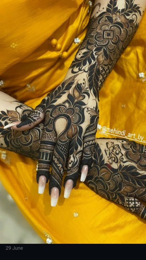 a woman's hands with henna tattoos on her arm and hand, showing the intricate