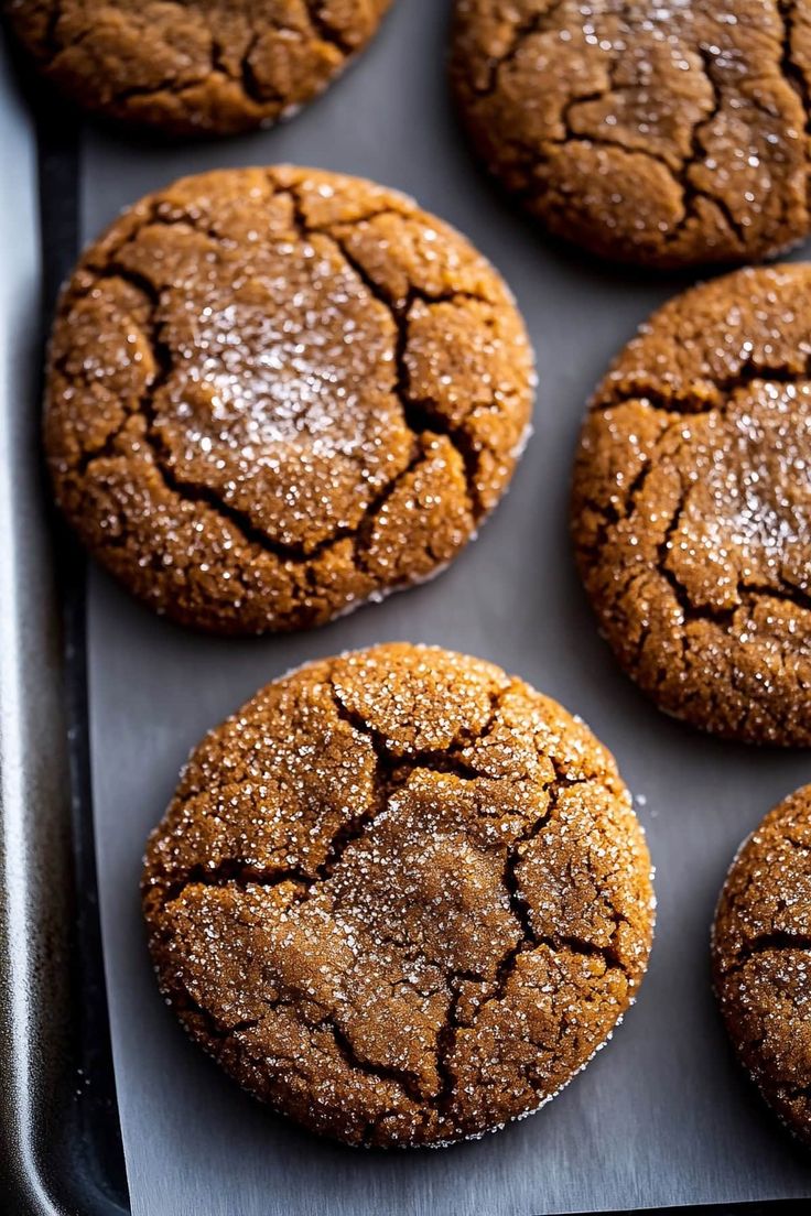 several cookies are on a baking sheet with powdered sugar