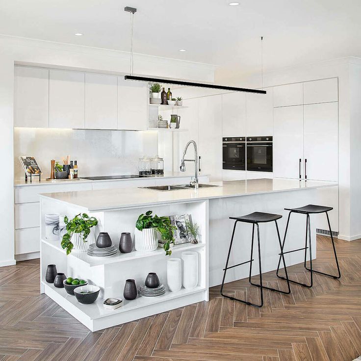 a kitchen with white cabinets and wooden floors