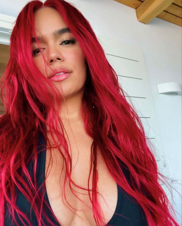 a woman with long red hair is taking a selfie