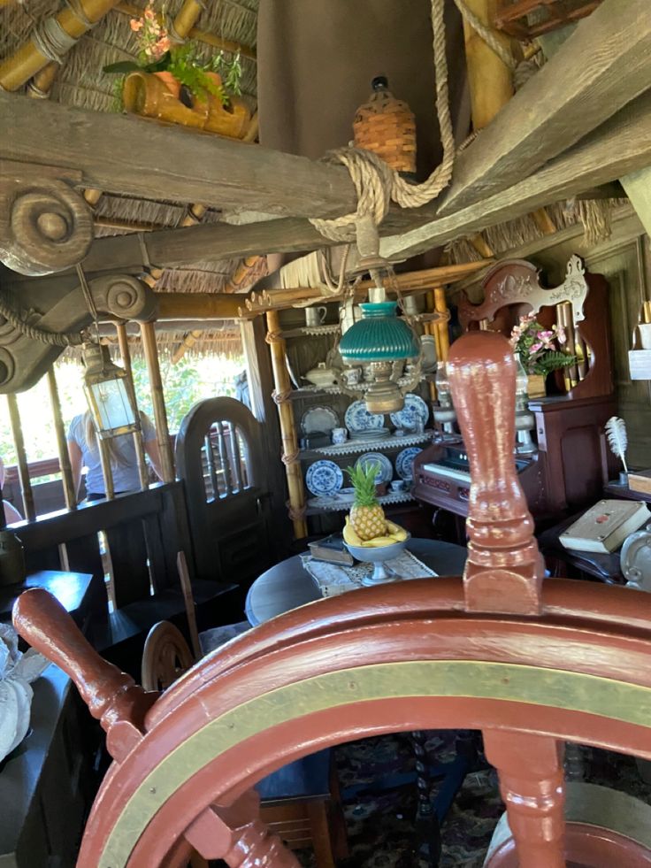 the inside of a boat with various items on display and decorations hanging from the ceiling