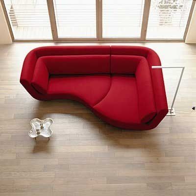 a red couch sitting on top of a hard wood floor