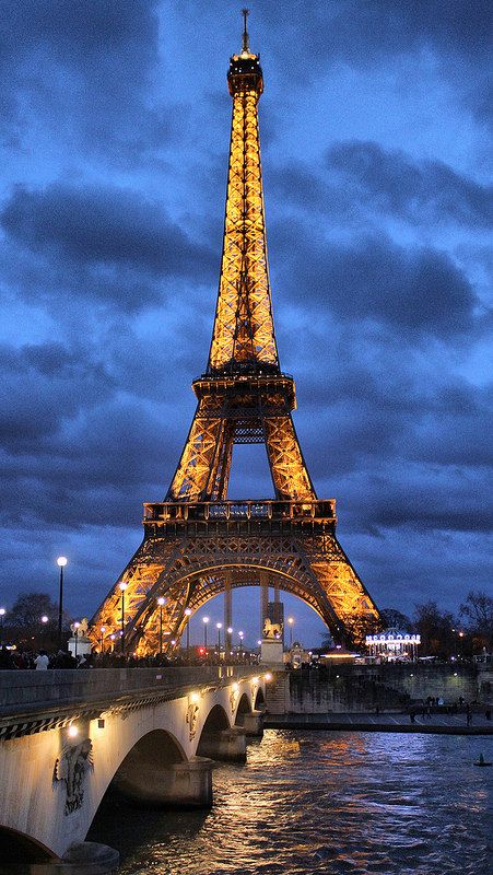 the eiffel tower is lit up at night