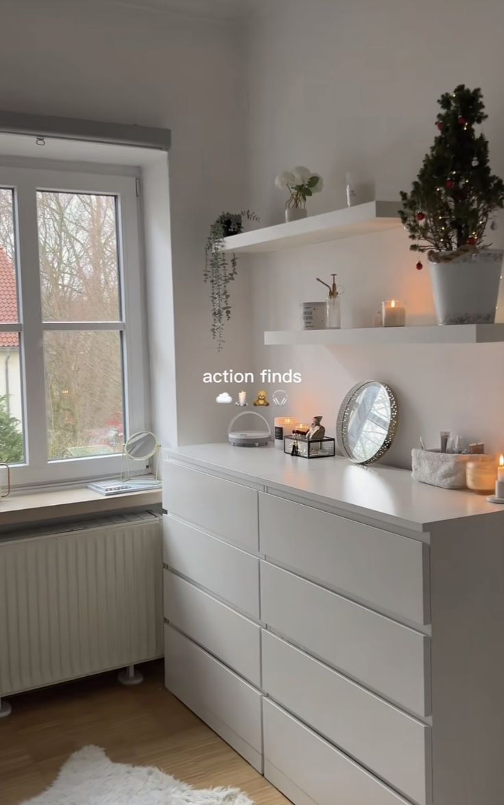 a kitchen with white cabinets and shelves next to a window