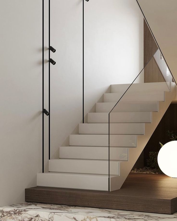 there is a white stair case next to the stairs in this modern home with marble flooring