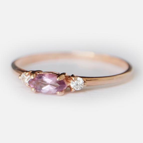 Engagement Ring Details14k Solid Rose Gold (Also available in White and Yellow Gold, Please select at checkout) 1.5mm (Approximate Band Width) Amethyst (Center Stone) Marquise 6X3mm (Center Stone Dimensions) 0.22 Carats (Average Center Stone Weight)Surrounding Diamond DetailsWhite Diamonds 0.06 Carats (Total Diamond Weight/ 2 Pcs.) SI-H (White Diamond) Brilliant CutRing can be resized from 3-10, Metal can be made in 14, 18K/ White, Yellow and Rose Gold.For custom order this ring with a different Topaz Wedding Ring, Ring Purple, Detailed Engagement Ring, Amethyst And Diamond Ring, Marquise Ring, Topaz Engagement Ring, Modern Engagement Rings, Amethyst Gold, February Birthstone