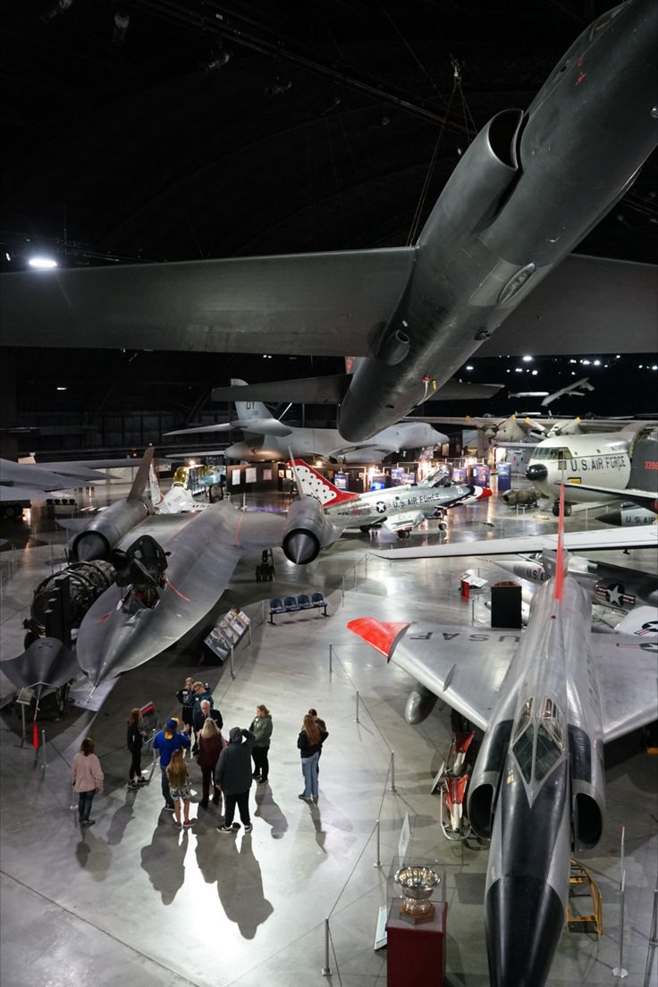 many people are looking at airplanes on display