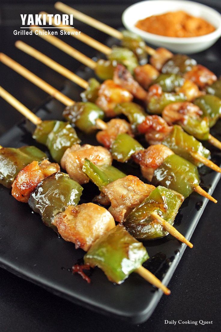 skewered chicken and peppers on a black plate