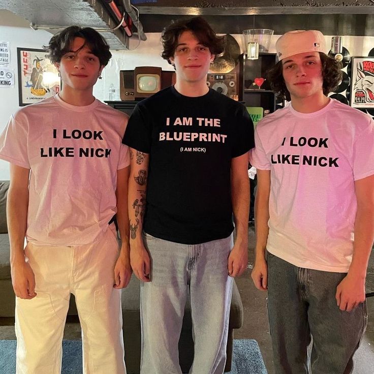 three young men standing next to each other wearing pink shirts with i am the blueprint on them