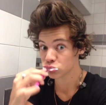 a young man brushing his teeth in front of a bathroom mirror with the caption harry styles