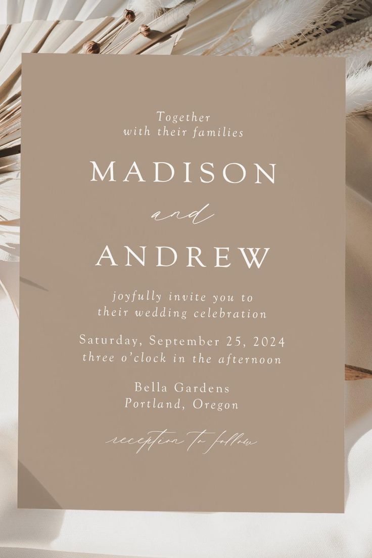 a wedding card with feathers on it and the words madison and andrew written in white