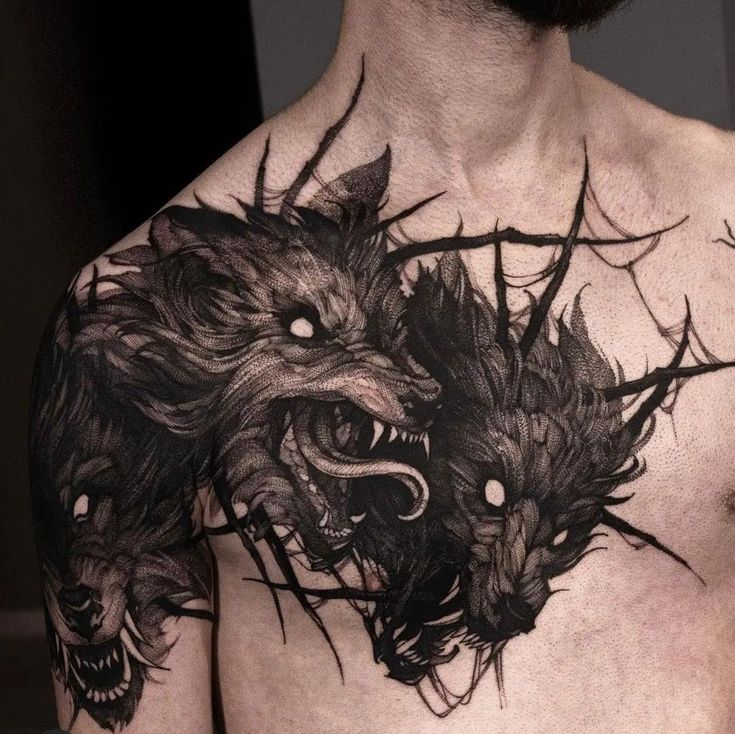 a man with tattoos on his chest has two wolfs in the middle of it