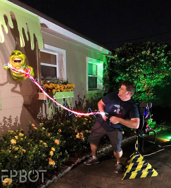 a man standing in front of a house with lights on it's face and mouth