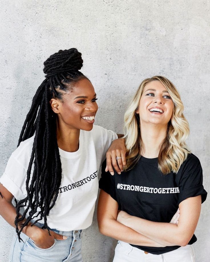 two women standing next to each other smiling