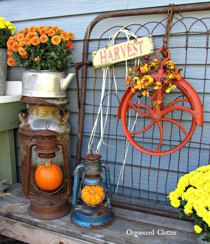 an assortment of pumpkins and gourds are hanging on the side of a house