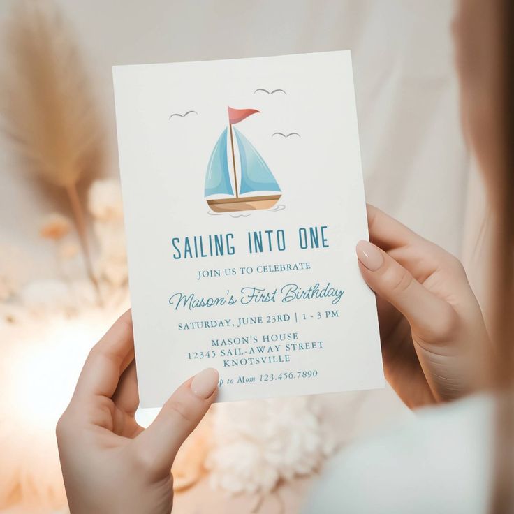 a woman holding up a birthday card with a sailboat on it